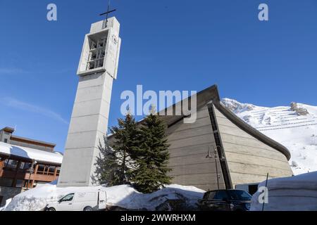 Die Kirche der Verklärung Christi des Berges, entworfen 1958 von Raymond Pantz, und der Glockenturm, der 1973 in Tignes, Frankreich, hinzugefügt wurde. Stockfoto