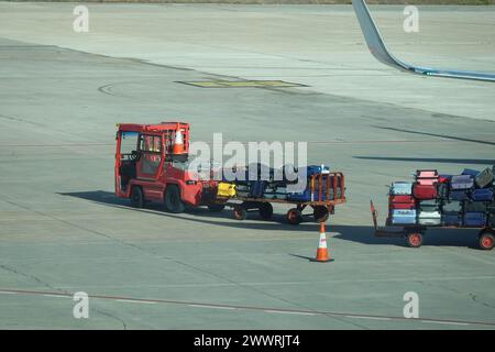 Gepäckanhänger für den Transport von Koffern zwischen dem Flughafenterminal und dem Flugzeug Stockfoto