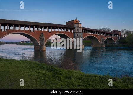 Schöne Aussicht auf Ponte Coperto (überdachte Brücke) ist eine Brücke über den Tessin Fluss in Pavia bei Sonnenuntergang, Lombardei, Pavia, Italien Stockfoto