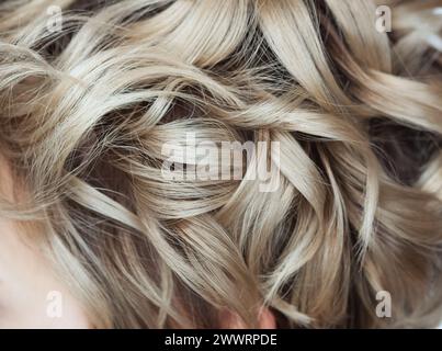 Lockiges blondes Haar in Nahaufnahme. Professionelle Haarpflege. Stockfoto