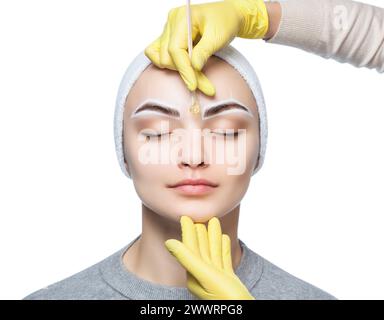 Die Make-up-Künstlerin zupft sich die Augenbrauen, bevor sie im Schönheitssalon dauerhaft schminkt. Stockfoto