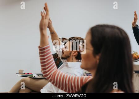 Engagierte Mitarbeiter heben die Hände und sind begierig, Fragen während des Seminars in der Vorstandssitzung zu stellen. Stockfoto