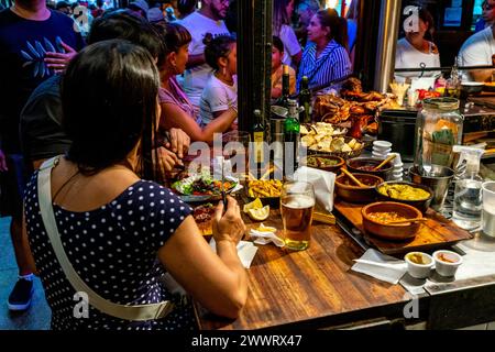 Leute, die in Einem Café auf dem San Telmo Indoor Market (Mercado de San Telmo) in Buenos Aires, Argentinien sitzen. Stockfoto