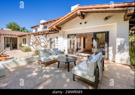 Terrasse mit Möbeln und weitläufigen Glastüren zum Blick auf den Hinterhof Stockfoto