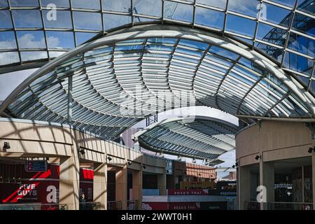 Moderne Glasdeckenarchitektur in einem Einkaufszentrum mit blauem Himmel und Wolken, sichtbar durch die transparente Struktur in Leeds, Großbritannien. Stockfoto