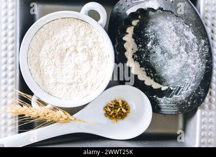Weizenähren und Mehl auf schwarzem Hintergrund Stockfoto