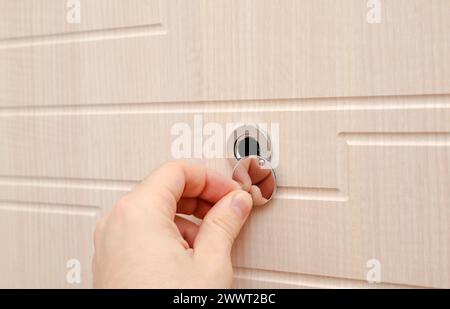 Hand in der Nähe des Türguts an einer neuen Holztür. Hochwertige Fotos Stockfoto