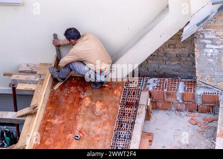 Der Bauingenieur prüft die Qualität der durchgeführten Arbeiten an der Dach- und Terrassenstruktur des Hauses. Stockfoto