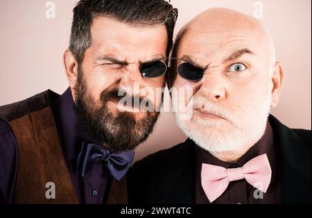 Generationen. Alter Vater und Sohn. Lustiger älterer Vater und erwachsener Sohn blicken in die Kamera. Generations-Konzept. Lächelnder älterer Herr und junge Männer mit Stockfoto