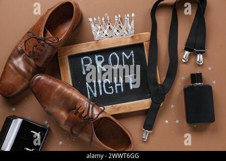 Tafel mit Text ABSCHLUSSBALL NACHT, männliche Schuhe und Hosenträger auf braunem Hintergrund Stockfoto