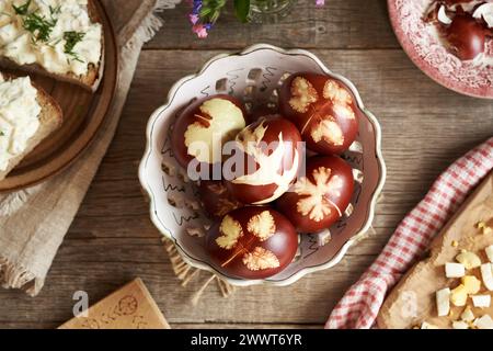 Braune Ostereier, gefärbt mit Zwiebelschalen und Sauerteigbrotscheiben mit Aufstrich aus hartgekochten Eiern, Blick von oben Stockfoto