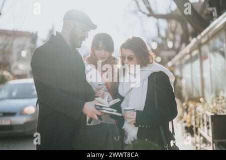 Drei Profis nehmen an einem sonnigen Wintertag an einem zwanglosen Geschäftstreffen Teil und tauschen Ideen aus, während sie das Wetter genießen. Stockfoto