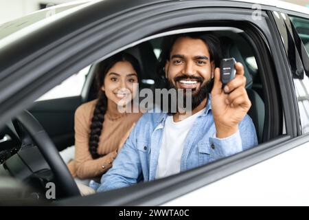 Ein Paar im Auto zeigt einen neuen Autoschlüssel Stockfoto