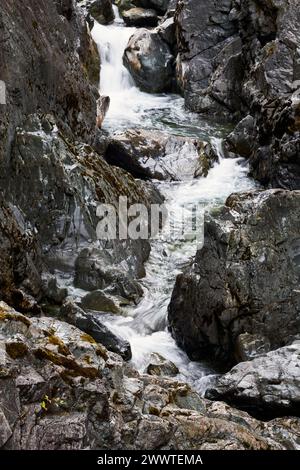 Ein kleiner Bach, der durch eine tiefe Schlucht zwischen zerklüfteten Felsen am Harris Creek fließt Stockfoto