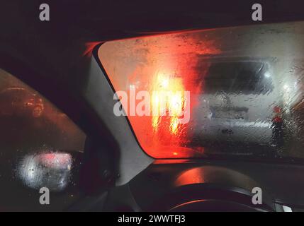 Blick aus dem Auto bei gefährlich schlechter Sicht bei Nacht mit Regen und blendender Hintergrundbeleuchtung, Deutschland Stockfoto