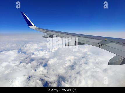 Blick vom Flugzeug über den Flügel zu den Wolken Stockfoto