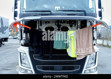 Trucker trocknet seine Wäsche am Motor mit geöffneter Motorhaube, Deutschland Stockfoto