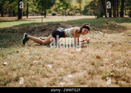 Eine professionelle Badmintonspielerin stürzt auf das Gras, nachdem sie vergeblich versucht hat, das Shuttle mit ihrem Schläger zu erreichen. Stockfoto