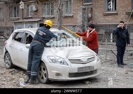 Kiew, Ukraine. März 2024. Ein Retter und ein Bewohner räumen ein Auto frei, das durch einen russischen Raketenangriff in Zentral-Kiew beschädigt wurde. Ein dreistöckiges Gebäude der Kiewer Akademie für Kunst und Design wurde durch den Raketenangriff am Morgen in Kiew zerstört. Nach Angaben des staatlichen Rettungsdienstes wurden mindestens zehn Personen verletzt. Quelle: SOPA Images Limited/Alamy Live News Stockfoto