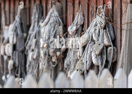 Alte alte Fischernetze Hintergrund. Authentisch verwendete Fischernetze hängen an einer Holzwand. Dekorative nautische Einrichtung. Stockfoto