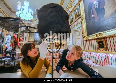 Apsley House, London UK 26 March 2024 (L) Olivia Fryman Keeper at Apsley House(R) Alex Seth -Smith Textile Conservator Preparing Field Marshall of the British Army Wellingtons Tall Bear Skin Hut, der heute noch von den Grenadier Guards zum ersten Mal in der Öffentlichkeit gesehen wird. Wellingtons Londoner Heimat wird neue Einblicke in diesen außergewöhnlichen Mann enthüllen. Quelle: Paul Quezada-Neiman/Alamy Live News Stockfoto