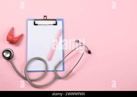 Endokrinologie. Stethoskop, Clipboard, Modell der Schilddrüse und Stift auf rosa Hintergrund, flache Lage. Leerzeichen für Text Stockfoto