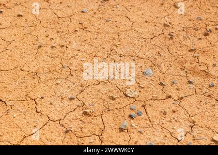 Trockenland oder gerissenes Land mit kleinen Steinen oder Kieselsteinen in Vollformat-Hintergrundfoto. Stockfoto