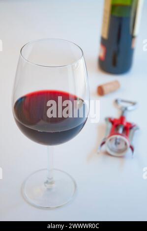 Glas Rotwein, Kork, Korkenzieher und Flasche. Stockfoto
