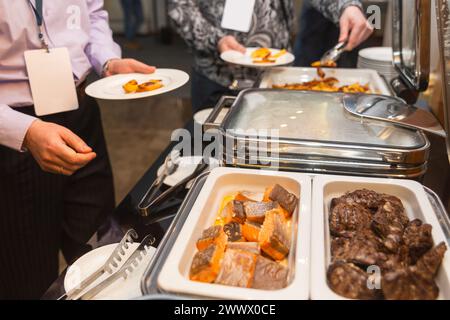 Die Teilnehmer des Business Seminars wählen während der Mittagspause in einem Selbstbedienungs-Buffetrestaurant Speisen aus Stockfoto