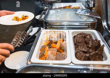 Die Teilnehmer des Business Seminars wählen während der Mittagspause in einem Selbstbedienungs-Buffetrestaurant Speisen aus Stockfoto