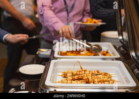 Die Teilnehmer des Business Seminars wählen während der Mittagspause in einem Selbstbedienungs-Buffetrestaurant Speisen aus Stockfoto