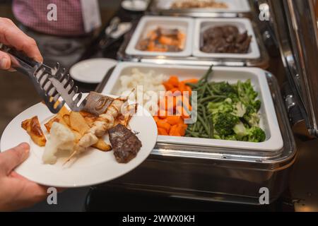 Die Teilnehmer des Business Seminars wählen während der Mittagspause in einem Selbstbedienungs-Buffetrestaurant Speisen aus Stockfoto