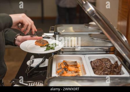 Die Teilnehmer des Business Seminars wählen während der Mittagspause in einem Selbstbedienungs-Buffetrestaurant Speisen aus Stockfoto