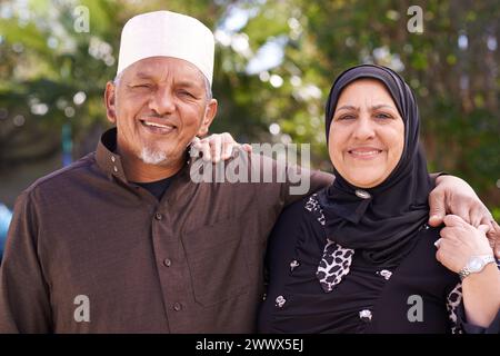 Seniorenpaar, muslimisch und umarmt mit Porträt, Garten und Ramadan für Kultur, Tradition und Ruhestand. Reifes, islamisches Volk und glückliche Ehe mit Stockfoto