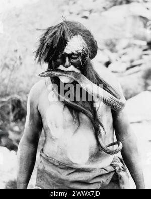 Hopi Indianer mit gemaltem Gesicht und Körper mit Schlange im Mund - 1924. Stockfoto
