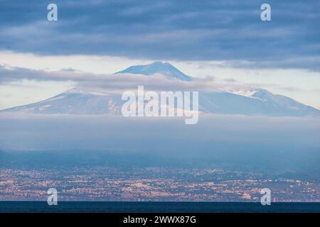 Blick über das Meer nach Catania, im Hintergrund liegt der Gipfel des Ätna. Vulkan Ätna Ätna 3357 m, Sizilien, Italien. Am Vulkan Ätna im Winter *** Blick über das Meer nach Catania, im Hintergrund ist der Gipfel des Ätna-Vulkans Ätna 3357 m, Sizilien, Italien am Ätna-Vulkan im Winter Stockfoto