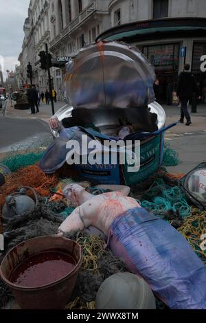 REKORDDATUM NICHT ANGEGEBEN Protest gegen Industrial Fishing in London Ocean Rebellion, eine Umweltaktivist-Gruppe, veranstaltet einen Protest in TESCO in der Regent Street in London. Der Protest zeigt eine riesige, 1,80 m große John West Thunfischdose, gefüllt mit drei Darstellern, die als toter Meervolk verkleidet sind und von Fischernetzen umgeben sind. Die Dose mit der Aufschrift JOHN WEST, THUNFISCHKLUMPEN, ist ein deutliches Symbol für die Opposition der Gruppen gegen industriell gefangenen Thunfisch, der ihrer Ansicht nach tödlich für die Meereslebewesen ist. Mit dem Protest soll das Bewusstsein für die Umweltauswirkungen industrieller Fischereipraktiken geschärft werden. London England United Stockfoto