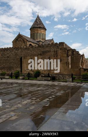 Die Svetitskhoveli-Kathedrale, eine orthodoxe christliche Kathedrale im Zentrum der historischen Stadt Mzcheta, Georgien, spiegelt sich in einer Pfütze wider Stockfoto