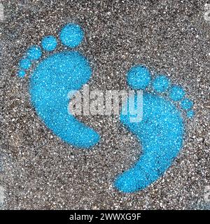 Blaue Fußabdruck-Schilder auf einer asphaltierten Straße für Fußgänger. Symbol für den Fußweg. Stockfoto