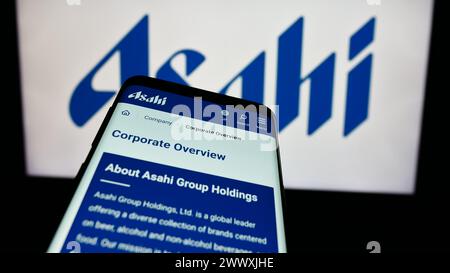 Mobiltelefon mit Website des japanischen Brauunternehmens Asahi Group Holdings Ltd. Vor dem Firmenlogo. Fokussieren Sie sich oben links auf der Telefonanzeige. Stockfoto