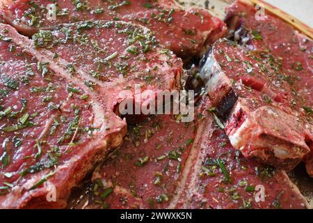 Tablett mit geschnittenem rotem Fleischsteak, gewürzt mit aromatischen Kräutern und Gewürzen für den Ostergrill Stockfoto