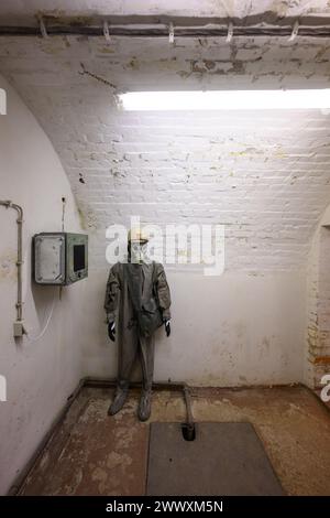 26. März 2024, Sachsen, Kšnigstein: Eine Schaufensterpuppe mit Schutzanzug und Gasmaske steht in einer Ecke während des Presserundgangs der neuen Ausstellung 'Nuklearbunker und Pulvermagazin' im ehemaligen Bunker für den DDR-Zivilschutz. Die Festung Königstein macht Räume des einst geheimen DDR-Bunkers im Festungswald, die in der Ausstellung selten zu sehen sind, im Rahmen von Führungen zugänglich. Foto: Robert Michael/dpa Stockfoto