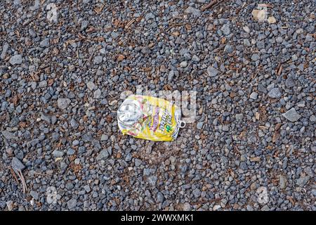 Eine helle und farbenfrohe Limonade oder Saft kann auf dem Boden auf dem Schotterparkplatz aus der Nähe mit Kopierraum flach werden Stockfoto