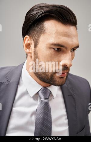 Nahaufnahme eines besorgten Geschäftsmannes in formeller Kleidung, der wegschaut, während er an Grau denkt Stockfoto