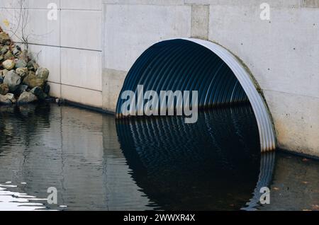 Entwässerungssystem unter einer Autobahn. Metallrohr unter einer Straße. Stockfoto