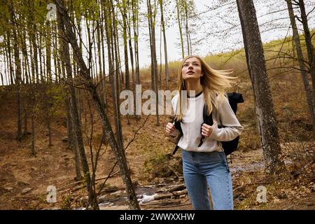 Junge Frau mit Rucksack, die im Wald spaziert, wandert und zeltet in der Natur Stockfoto