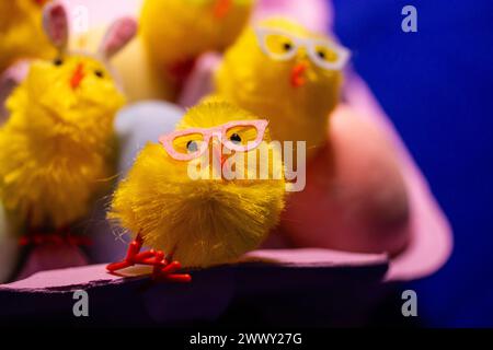 Stilvolle gelbe fröhliche Osterhühner in rosa Sonnenbrille feiern die Freude an den Osterferien. DIY bastelt saisonale Dekoration für Frühlingsfeste. Stockfoto