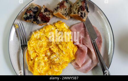 Rührei mit Schinken und Blaubeermuffin Stockfoto