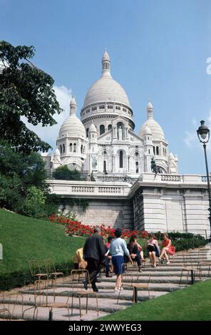 1960er Jahre, historisch, Besucher, die die Treppen in Sacre-Coeur, Montmartre, Paris, Frankreich hinaufgehen. Die Basiica Sacre-Coeur de Montmartre ist eine römisch-katholische Kirche, die auf einem Hügel in der französischen Stadt erbaut wurde und 1914 fertiggestellt wurde. Stockfoto