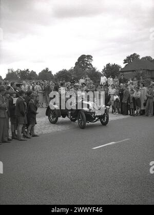 1950er Jahre, historisch, eine Menschenmenge, die einen Oldtimer mit offenem Oberdeck, Nr. 39, Kennzeichen P 4460, ohne Türen, zu Beginn eines Oldtimer-Rennens anfährt, England, Großbritannien. Autos, die vor dem 1. Weltkrieg gebaut wurden, gelten allgemein als Veteranenwagen, obwohl die strenge Interpretation besagt, dass nur Fahrzeuge, die vor 1904 gebaut wurden, als Veteranenautos bezeichnet werden können und dass Autos, die zwischen 1905-1918 gebaut wurden, als Edwardianische Autos bezeichnet werden sollten. Autos, die zwischen 1919 und 1930 hergestellt wurden, werden im Allgemeinen als Vintage klassifiziert. Stockfoto